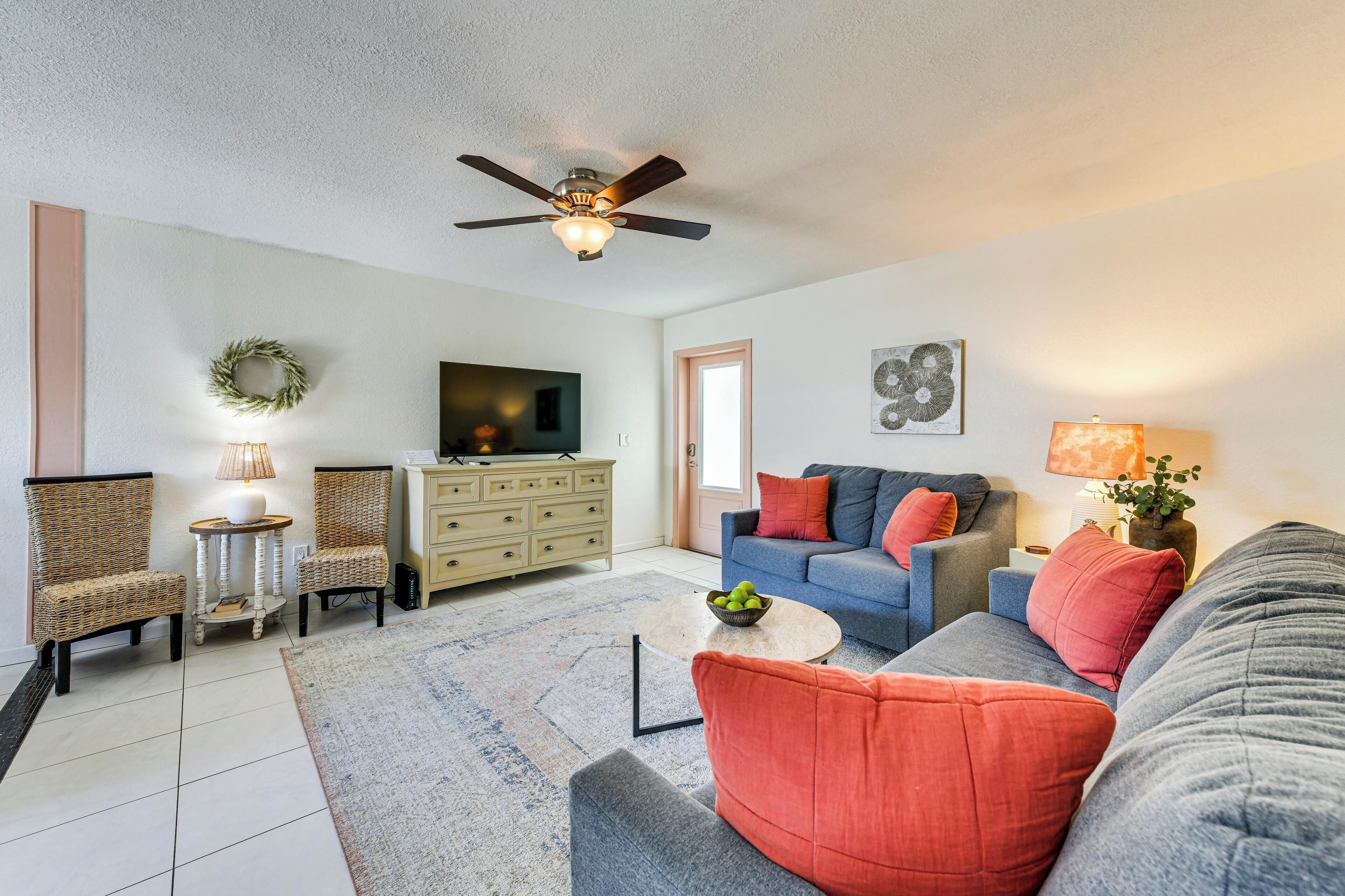 A living room with a ceiling fan, a television, a sofa, and a coffee table.