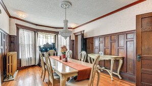 Ein Esszimmer mit Holztisch, Stühlen, einer Pendelleuchte und einer Heizung.