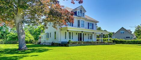 A two-story house with a large front porch, a covered entryway, and a well-maintained lawn.