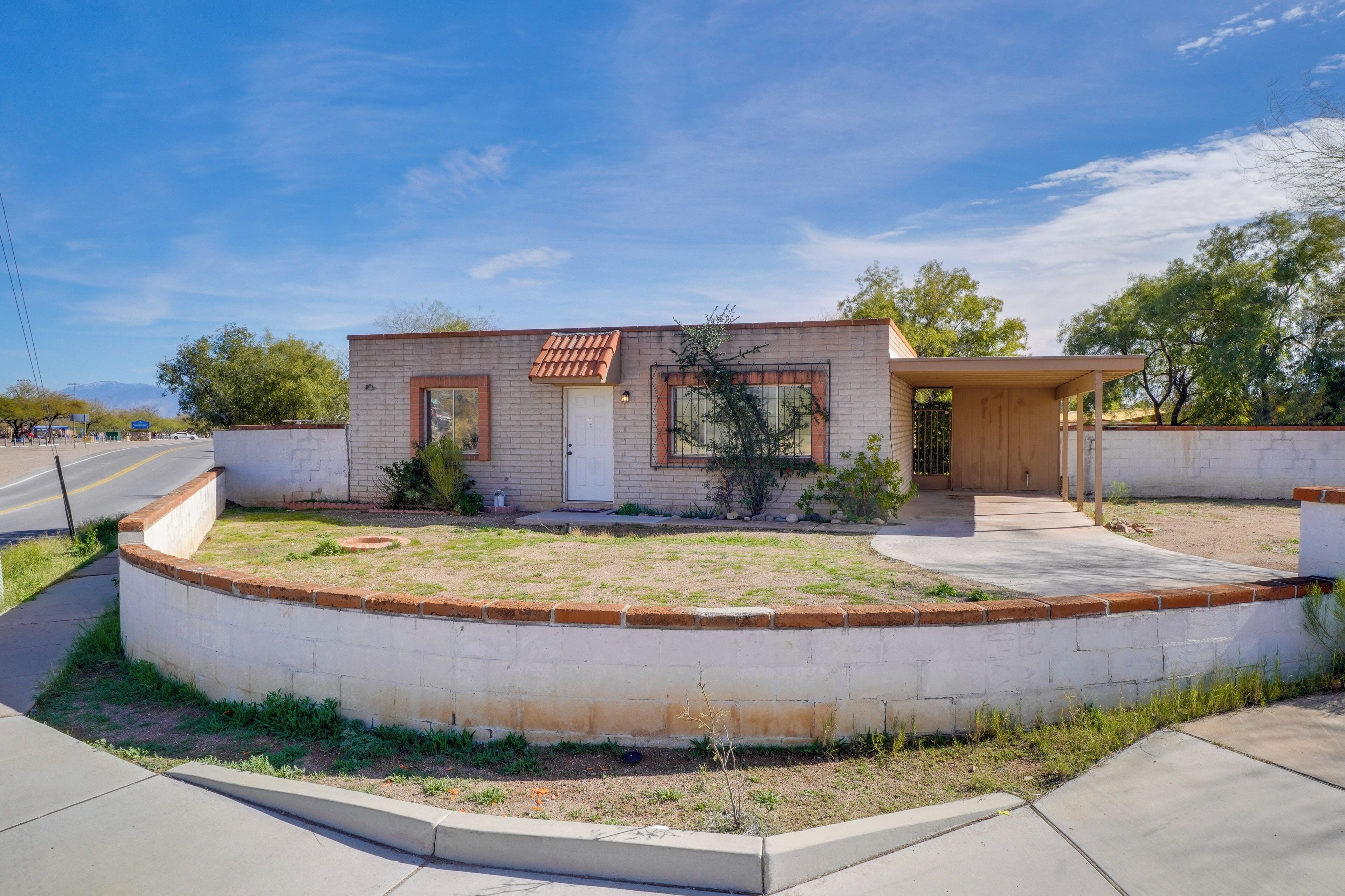 A modern single-story house with a brick exterior, a small front yard, and a covered porch.
