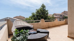 A rooftop terrace with a round wicker table and chairs, a potted plant, and a white canopy. - Spacious family villa in Narbonne-Plage for 6 people, private parking, pets allowed (Narbonne-Narbonne Plage-Narbonne Plage)