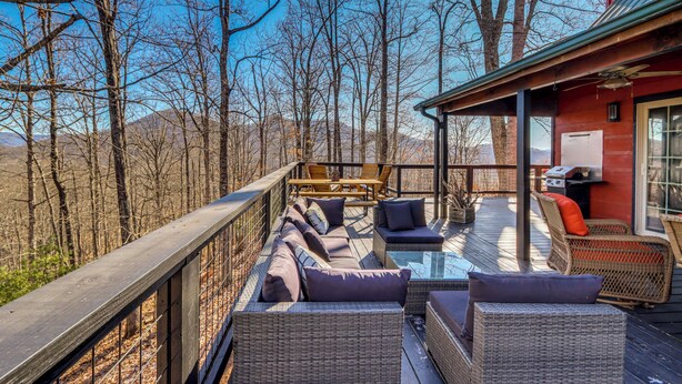 A deck with wicker furniture and a glass table, overlooking a forested area. - Mtn-view Cabin w/ Hot Tub Near Blairsville Trails (Blairsville)
