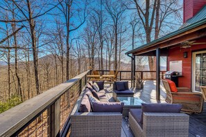 A deck with wicker furniture and a glass table, overlooking a forested area. - Mtn-view Cabin w/ Hot Tub Near Blairsville Trails (Blairsville)