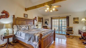A spacious bedroom with a large wooden bed, a ceiling fan, and a window with curtains. - Mtn-view Cabin w/ Hot Tub Near Blairsville Trails (Blairsville)