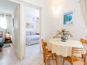 A bedroom with a bed, bedside table, and a nightstand. There is a door leading to another room. - Renovated house near the sea with air conditioning and WIFI (Fleury-Saint-Pierre-la-Mer)