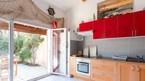 Uma cozinha moderna com armários vermelhos, uma janela grande e vista para o exterior.