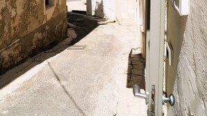 A narrow alleyway between buildings with a door on the right side. - La Chianca Rosa - Arcuève (Ostuni)