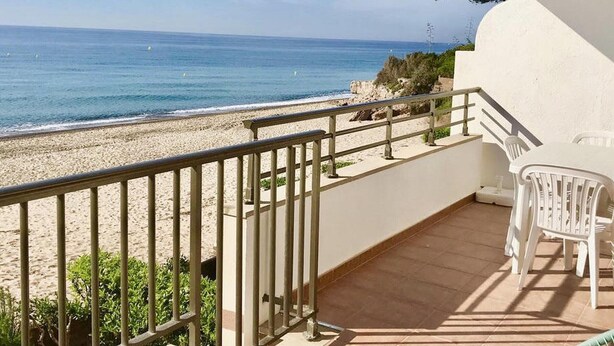 Ein Balkon mit Blick auf Strand und Meer.