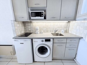 A compact kitchen with a microwave, coffee maker, sink, and washing machine. - Beachfront Studio with A/C and Parking in Port Grimaud (Port Grimaud)