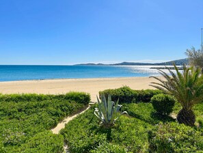 Une plage offrant une vue dégagée sur la mer et les collines lointaines.