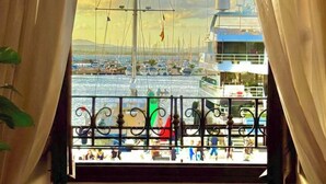 A balcony with a view of a marina, including boats and a distant shoreline. - ClickSardegna – Elegant historic palace with sea view in the old town, with lift (Alghero)