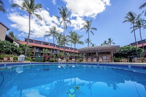 A swimming pool with lounge chairs and palm trees. - Luana Kai B-208 Full A/C, Ocean, pool & courtyard views! (Kihei)