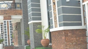 A modern building with a grey and white facade, brick lower levels, and a checkered floor pattern. - La Villa Resort And Hotel  (Awka)