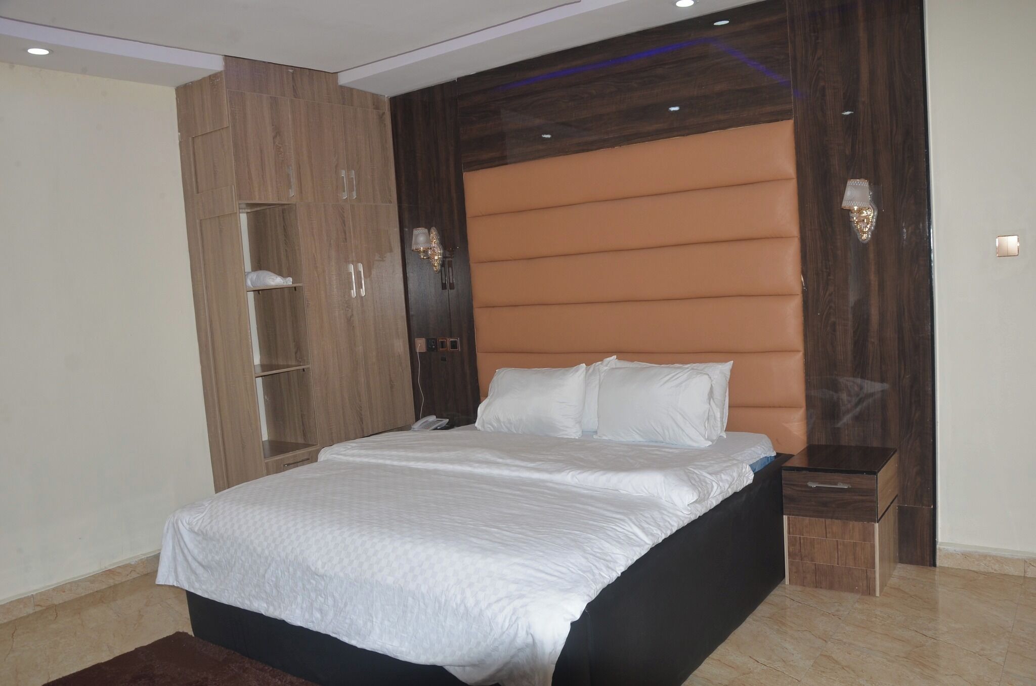 A bedroom with a bed, a wardrobe, and a nightstand.
