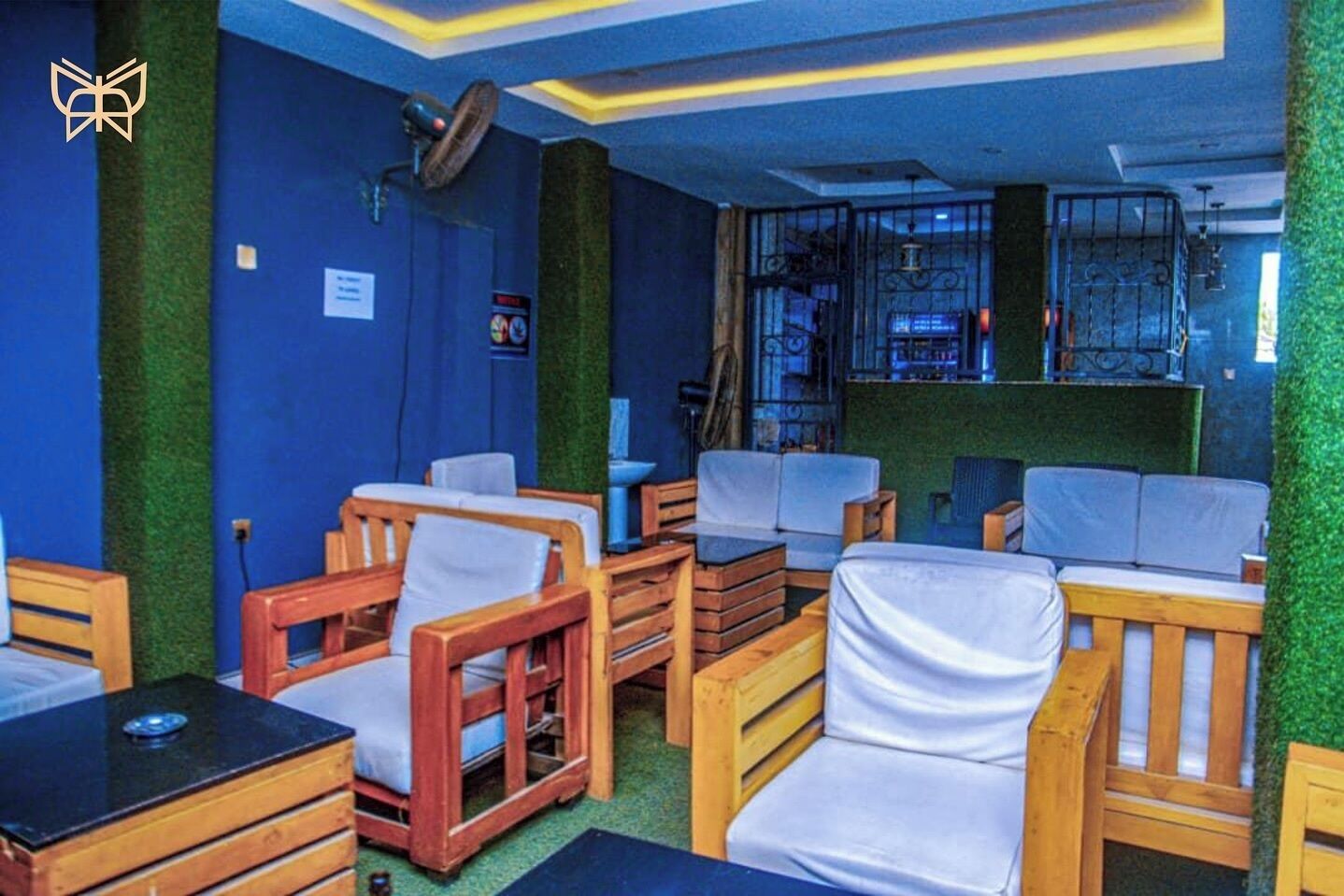 A room with wooden furniture, green walls, and a bar area.