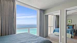 A bedroom with a large window offering a view of the ocean. - Shoreline Towers 1102 2 Bedroom Condo (Destin)