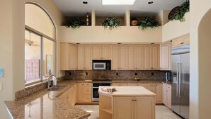 A kitchen with granite countertops, stainless steel appliances, and light wood cabinets. - The Family Room-Pool & Outdoor Games-Game Room (Scottsdale)