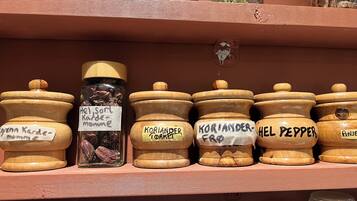 A shelf with various jars labeled with names of spices and herbs.