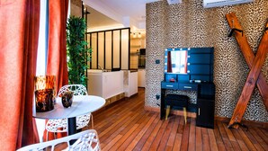 Une cuisine moderne avec des meubles blancs, un réfrigérateur noir et un mur d’accent orné d’un motif léopard.