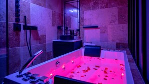 Une salle de bain moderne avec une grande baignoire, un miroir et un meuble-lavabo.