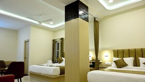 A hotel room with two beds, a desk, a chair, and a bathroom.