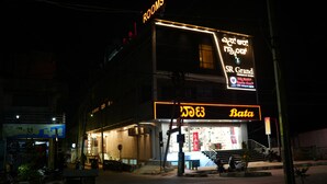 A building with multiple signs, including 'Rooms' and 'Bata' indicating commercial spaces.