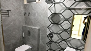 A bathroom with a toilet, a sink, and a shower.