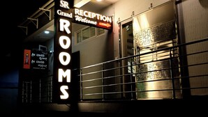 A building entrance with a reception sign and a sign for rooms.