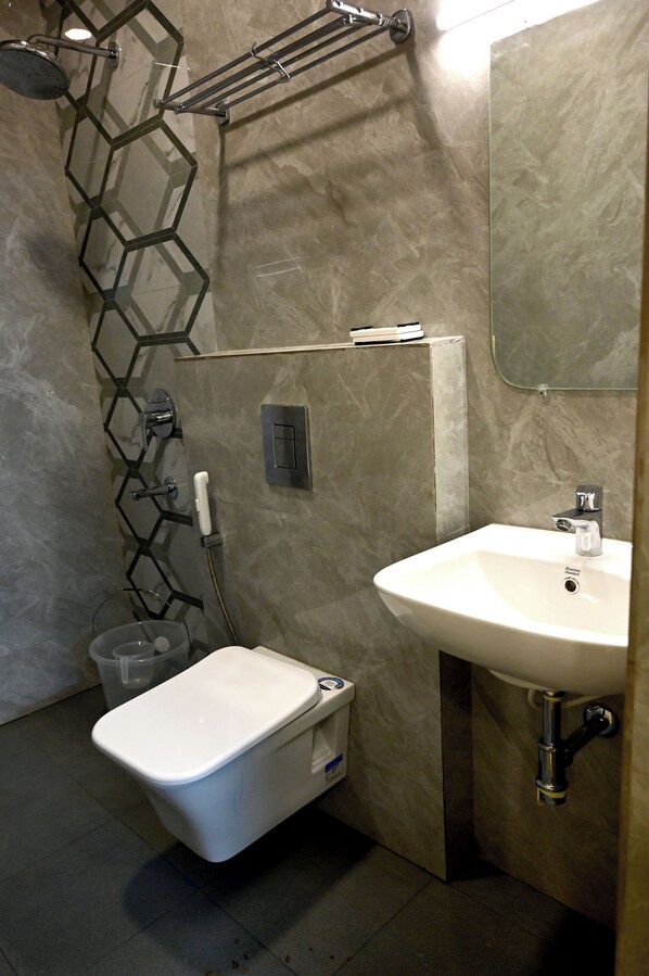 A modern bathroom with a toilet, sink, and shower.