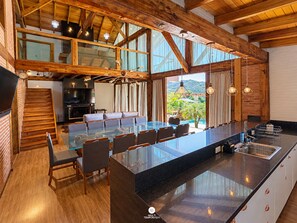 Una cocina amplia con una isla grande, vigas de madera y vistas a una piscina.