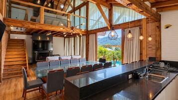 Una cocina espaciosa con una isla grande, vigas de madera y vistas al exterior.