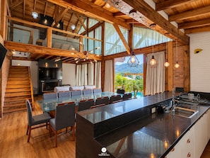 A spacious kitchen with a large island, wooden beams, and a view of the outdoors. - Sítio Recanto Pedacinho do Céu - Camboriú/SC (Camboriú)