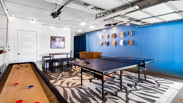 Une pièce équipée d’une table de jeu de palet, d’une table de ping-pong et d’un baby-foot.
