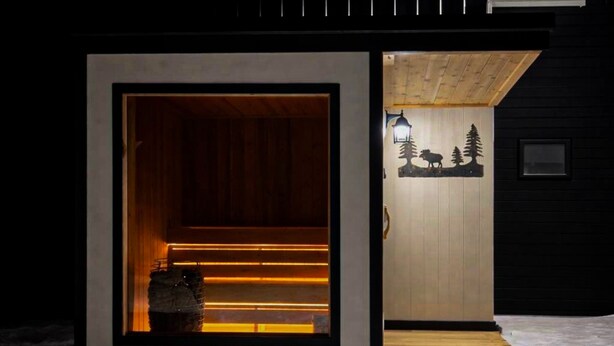 A modern, minimalist building with a wooden interior and a small outdoor area with a bench. - Private Sauna I 1.7 mi to Lutsen Mountain I Ski I Bike I Hike (Lutsen)