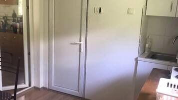Una cocina con puerta blanca, un lavamanos y una encimera.