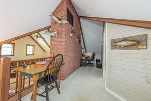 Ein Essbereich mit Backsteinwand, einem Holztisch und einem Stuhl.