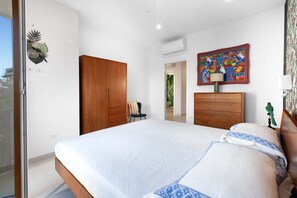 A bedroom with a large bed, wooden wardrobe, and a colorful abstract painting on the wall. - Estate4home - Velia in Sorrento (Sorrento)