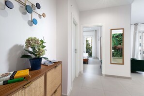 A hallway with a wooden console table, a potted plant, and a wall-mounted decorative item. - Estate4home - Velia in Sorrento (Sorrento)