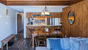 Un espace de vie de style loft comprenant un coin repas, un canapé et un plafond en bois.