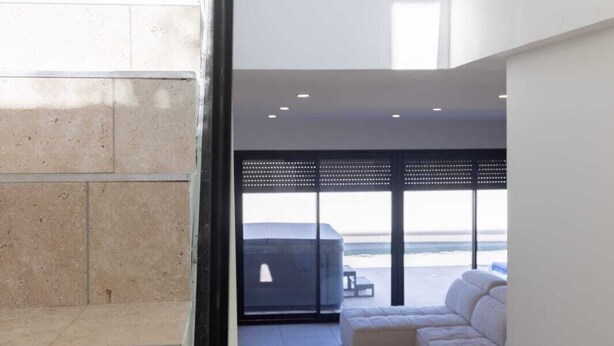 Een modern interieur met een groot raam, een hoekbank en een minimalistisch design.