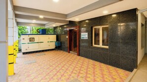A hotel lobby with a tiled floor, a reception desk, and a sign indicating the hotel name. - Blessing Select DLF (Chennai)