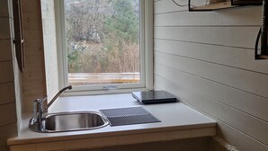 A kitchen with a window, a sink, and a countertop. - Quaint 1-bedroom basement apartment in charming Vestland (Vestland)