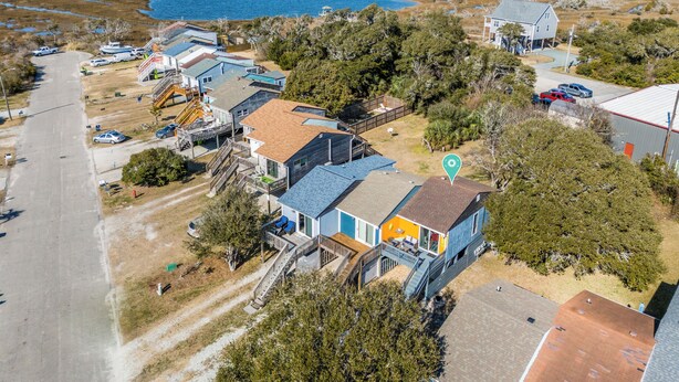 Ett flygbildsbild av ett bostadsområde med hus, en brygga och en stor vattenyta.
