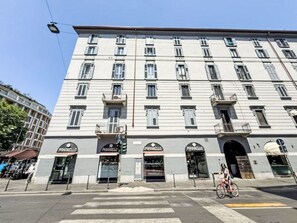 Un edificio a più piani con diverse attività commerciali al piano terra, tra cui una farmacia.