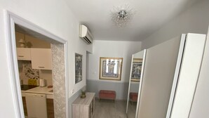A narrow hallway with a kitchen area on the left, a bench, and a mirror on the right. - Lady M in Rabac - Istrien / Lady M in Rabac - Appartement für 4 Personen AP1 (Rabac)