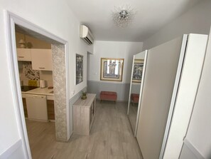 A narrow hallway with a kitchen area on the left, a bench, and a mirror on the right. - Lady M in Rabac - Istrien / Lady M in Rabac - Appartement für 4 Personen AP1 (Rabac)