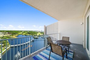 Ein Balkon mit Blick auf einen See und eine Stadtansicht, ausgestattet mit einem Tisch und Stühlen.
