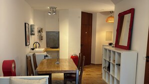 A compact living space with a dining table, chairs, a sofa, a TV, and a mirror. - Vacation apartment on the Moselle (Koblenz)