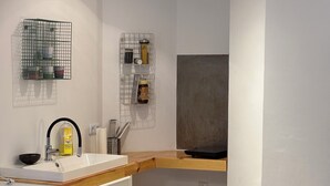 A compact kitchen with a wooden countertop, a sink, a microwave, and a red trash bin. - Vacation apartment on the Moselle (Koblenz)
