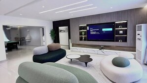 A modern living room with a flat-screen TV, comfortable seating, and a minimalist design. - Decobel Apartment (Abuja)